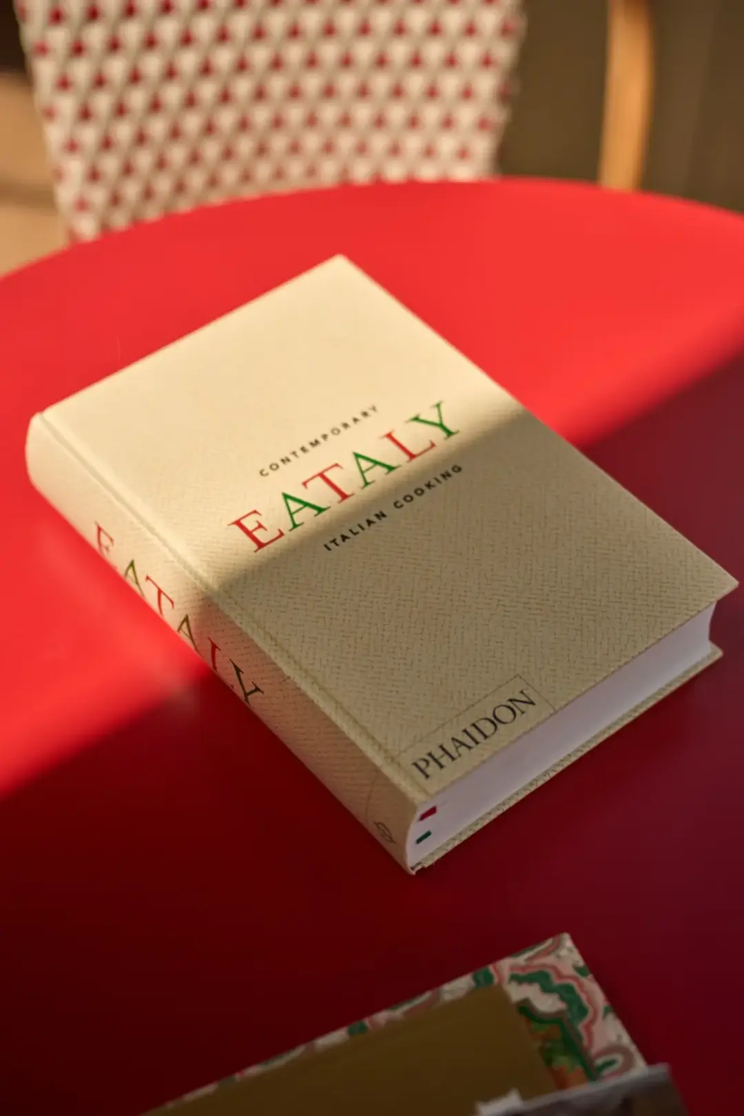 Livro Eataly na mesa vermelha do Soleil